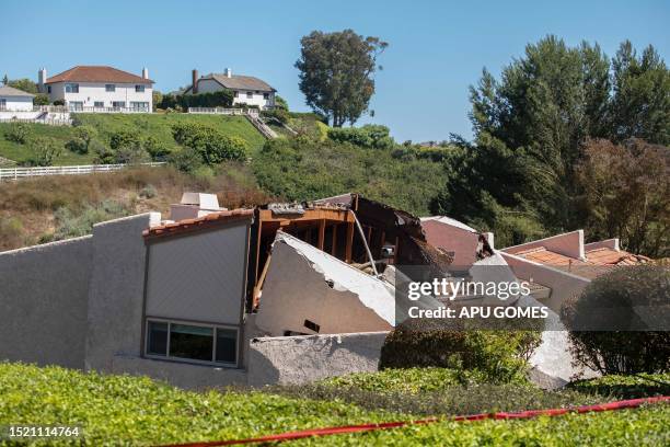 Collapsed homes are pictured as they slid down a hill along a street at the Rolling Hills States neighborhood fall along with it, in Rancho Palos...