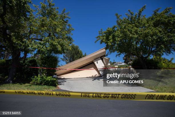 Collapsed homes are pictured as they slid down a hill along a street at the Rolling Hills States neighborhood fall along with it, in Rancho Palos...