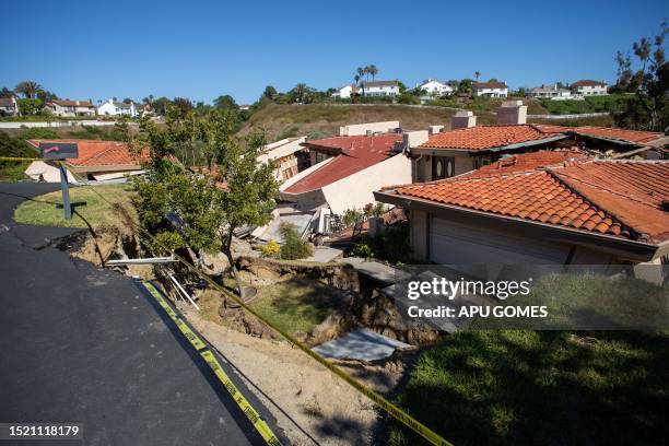 Collapsed homes are pictured as they slid down a hill along a street at the Rolling Hills States neighborhood fall along with it, in Rancho Palos...