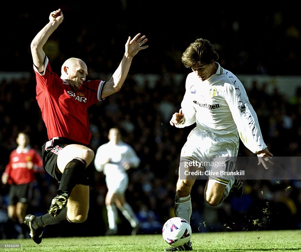 Jaap Stam of Manchester United challenges Harry Kewell of Leeds United