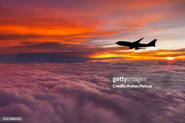airplane at sunset above the clouds. - clouds from aircraft point of view stock pictures, royalty-free photos & images