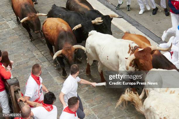 Crowds of people run during the first running of the bulls of the Fiestas de San Fermin 2023, with bulls from Puerto de San Lorenzo, on July 7 in...