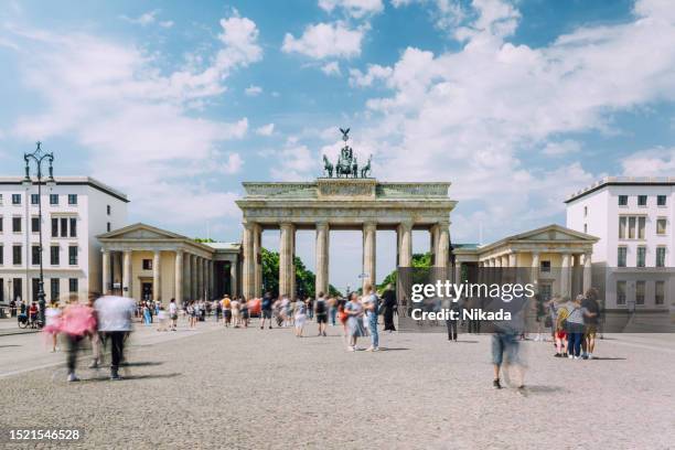 dynamic crowd, brandenburg gate, berlin, daytime, bustling city, blurred motion, lively atmosphere. - brandenburg gate berlin stockfoto's en -beelden