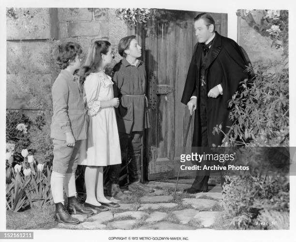 Dean Stockwell, Margaret O'Brien, and Brian Roper all look over to Herbert Marshall in a scene from the film 'The Secret Garden', 1949.
