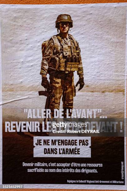 Affiche anti-militariste "ALLER DE L'AVANT" REVENIR LES PIEDS DEVANTS ! édité par le Collectif Régional Anti-Armement et Militarisme sur un mur du...