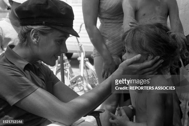 Geneviève Grad avec une enfant lors du tournage du film 'Le gendarme se marie' à Saint-Tropez le 10 juillet 1968