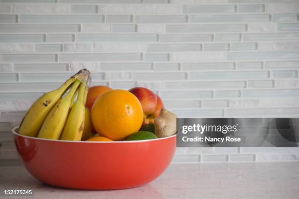 fresh fruit in red bowl - fruitschaal stockfoto's en -beelden