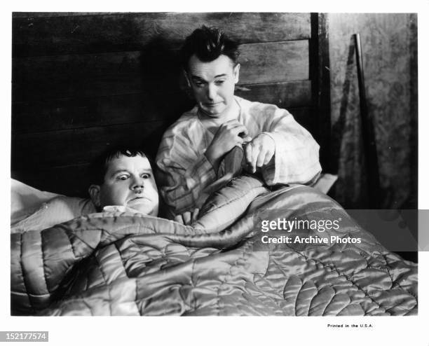 Frightened Oliver Hardy and Stan Laurel in bed together in a scene from the short 'They Go Boom!', 1929.