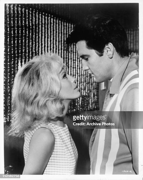 Nancy Sinatra looking up at Elvis Presley in a scene from the film 'Speedway', 1968.
