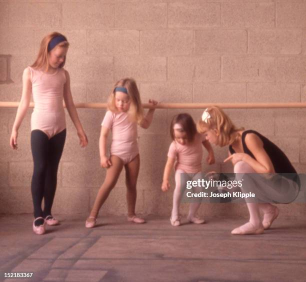 American dancer and dance instructor, and future actress, Goldie Hawn examines the foot positions of her young ballet students, Washington DC, 1964.