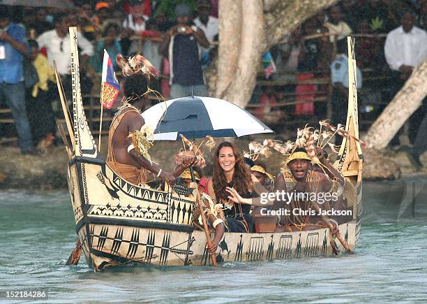 Catherine, Duchess of Cambridge and Prince William, Duke of Cambridge are followed by locals dressed as 'sharks' as they travel in a traditional...
