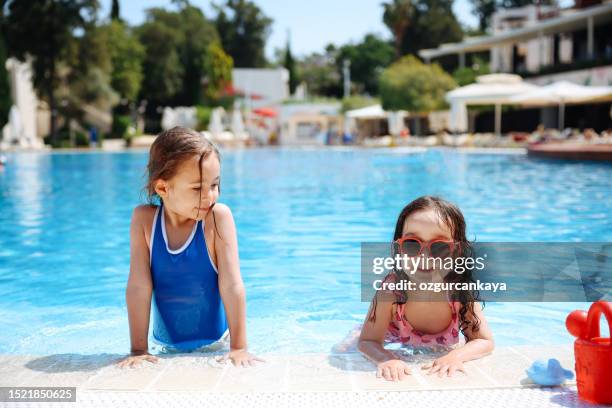 happy child girls enjoying in the pool - girls swimwear stock pictures, royalty-free photos & images