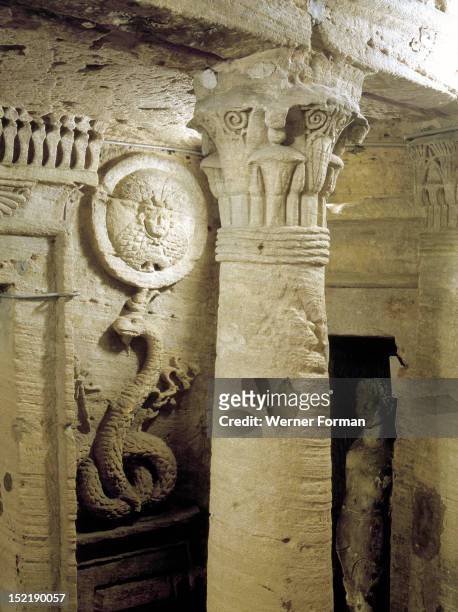 The extensive complex of burial chambers at Kom el-Shuqafa, combining Greek and Egyptian design elements, View of a column with decorated capital, a...