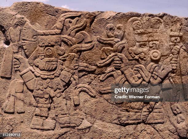 Relief showing Tlaloc, the rain god bringing blessings to the maize goddess, Each deity holds a maize plant with ripened cobs towards the other....