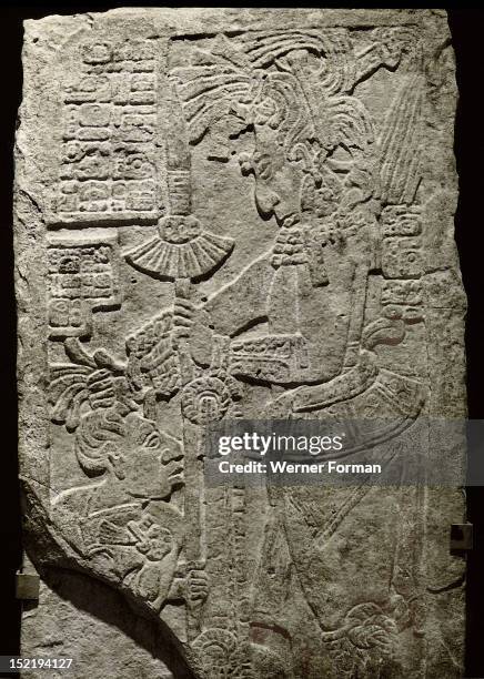 Relief from the stela 10 depicting a ruler holding the hair of a prisoner who kneels in supplication in front of him, The ruler is holding a spear...