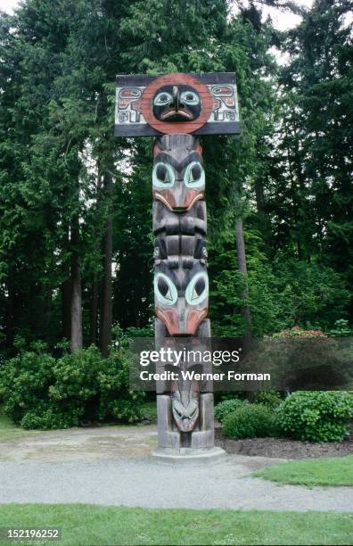 Totem pole with hawk or sunbird false box on the top, The poles were usually erected at potlatches and formed the link between the human groups and...