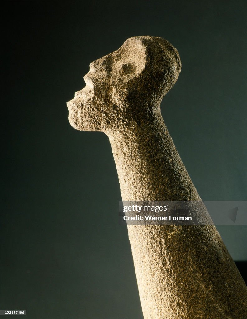 Stone pounder, with human head on the butt and chevrons at the mid point representing arms