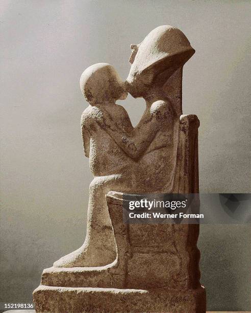 Akhenaten kisses his daughter as she sits on his lap, An unfinished statue. Full, profile view. Egypt ,Ancient Egyptian. Amarna period c 1373 1357...