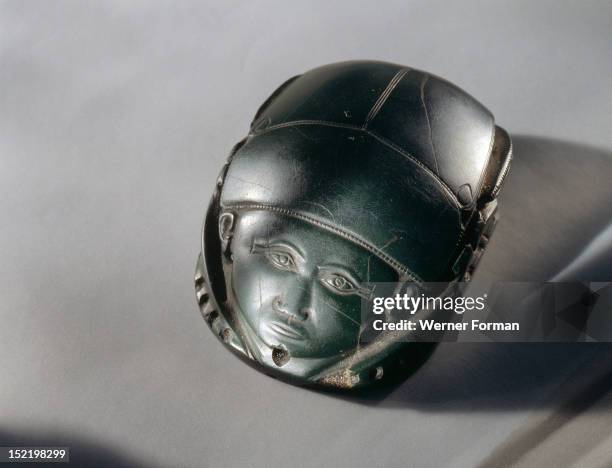 Human faced heart scarab, which was placed on the deceaseds heart during burial rites, The original Middle Kingdom text on the base has been erased...