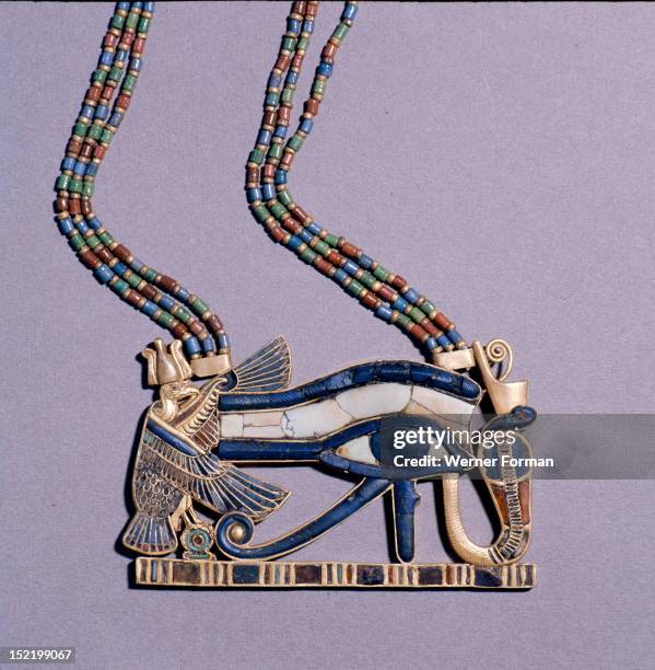 Pendant from the tomb of Tutankhamun in the form of a Wedjat eye, symbol of protection, flanked by the vulture goddess, Nekhbet and the snake goddess...