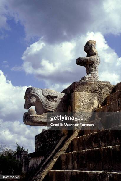 Carved stone head of snarling Kukulcan , On top of the head, a Maya warrior flanks the top of the monumental stairway, which gives access to the...