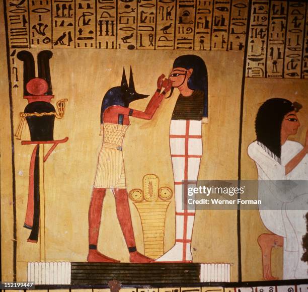 Painting in the tomb of Inherkha, A priest wearing the mask of Anubis, god of mummification, is proffering to the mummy a bowl of holy water. The...