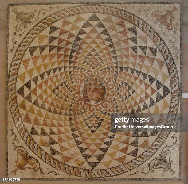 Mosaic of a Roman villa decorated with geometric motifs and Dionysius head with fruit and ivy in hIs hair in the center, Pitchers with ivy in the...