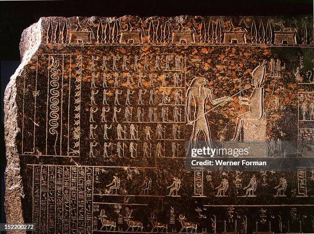 Detail from a sarcophagus depicting Horus reviving with the ankh, sign of life, his father Osiris, while standing deities raise their hands in...