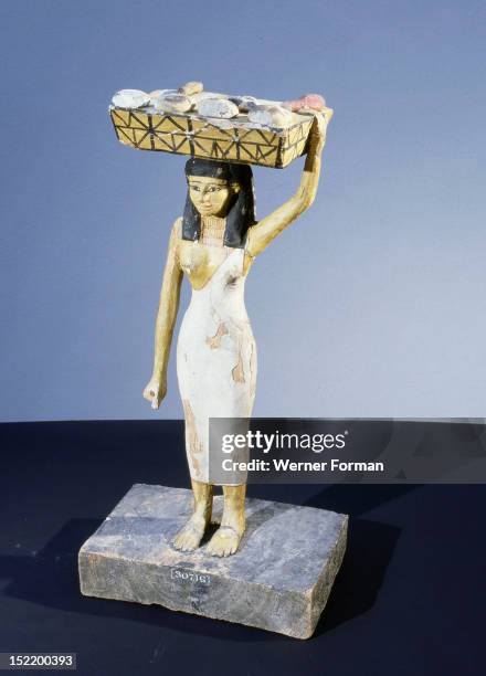 Model of a servant girl carrying on her head a basket of loaves and pieces of meat, Egypt ,Ancient Egyptian. Middle Kingdom.