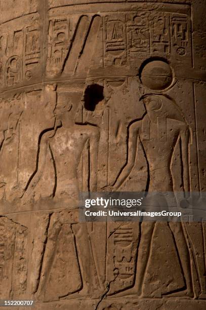 Relief with god Amon ' the mysterious', helmet covered with two large feathers and beard, Behind him RA, higher solar god represented with a falcon's...