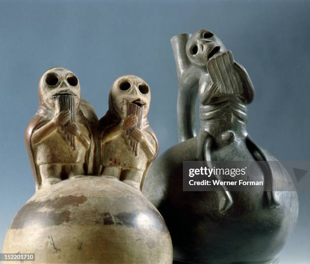 Two stirrup spouted Mochica jars depicting skeletal figures playing typically Andean pan pipes, Such scenes are frequent in Mochica art and seem to...