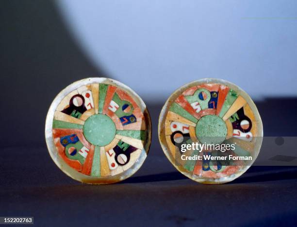 Two discs of turquoise and shell , portraying alternating stylised representations of a bird and a feline, perhaps a condor and a puma, Used either...