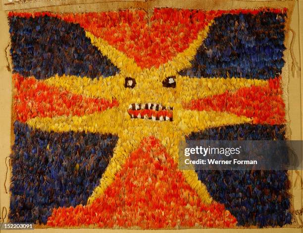 Featherwork tabard from the Nazca/Huari transitional period, Detail. The design of dragons and sun is worked in red, blue, and yellow macaw feathers...