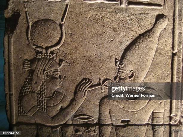 Relief from the inner sanctum wall of the Temple of isis depicting the goddess resurrecting Osiris with the ankh, the Egyptian sign for life, Egypt....