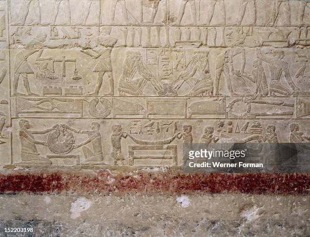 Relief in the tomb of Mereruka showing metalworkers and dwarfs employed in the manufacture of jewellery, The metalworkers use blowpipes to force the...