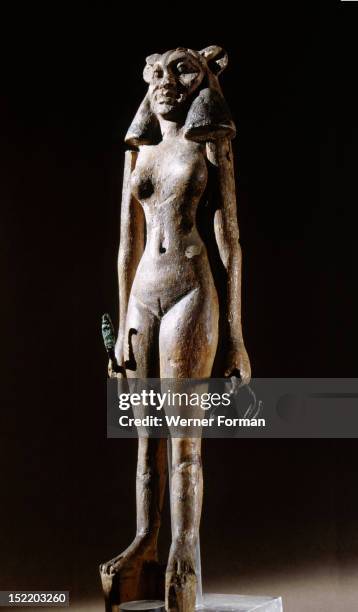 Figurine of a nude female dancer wearing a leonine mask, holding a bronze serpent in each hand, Found in a chest full of papyri bearing incantations...