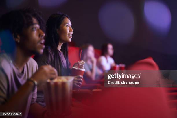 happy asian woman enjoying in a movie at cinema. - movie premiere stock pictures, royalty-free photos & images