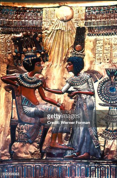 The back of the throne of Tutankhamun, Queen Ankhesenamun holds a salve cup and spreads perfumed oil on her husbands collar in a typical Amarna style...