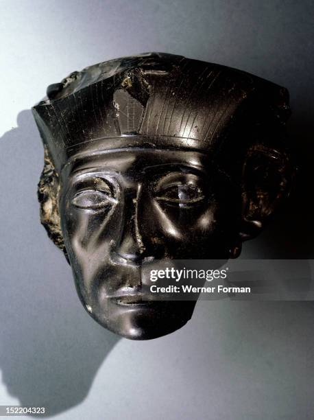 An obsidian head, thought to be part of a statue depicting Senwosret III as a middle aged man, He is wearing the nemes headcloth and a uraeus, symbol...