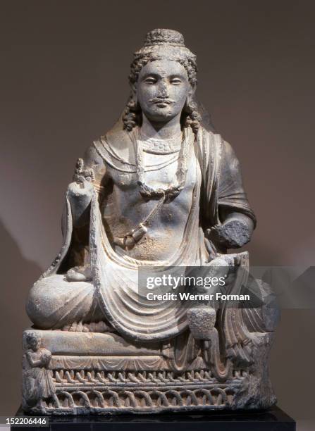 Statue of Maitreya, the Buddha of the Future, depicted as the Reassuring Maitreya, Sitting on a throne of woven cane, with the donor of the statue to...