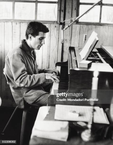 The French singer and composer Gilbert Bécaud playing piano. 1959