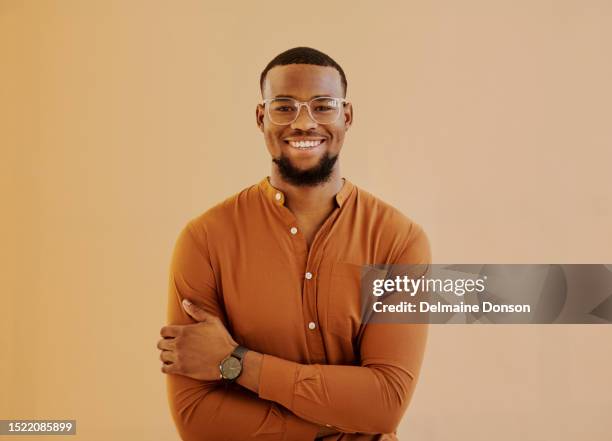 young businessman standing while smiling at camera with copy space. stock photo - black shirt folded stock pictures, royalty-free photos & images