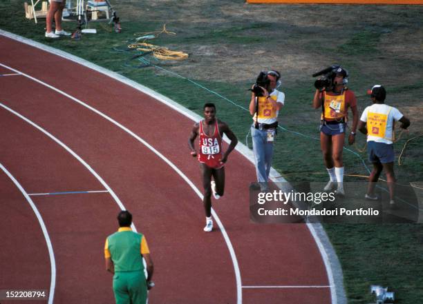 The American sprinter and long jumper Carl Lewis running on the track filmed by the cameras after winning a final race at Los Angeles Olympics. Los...