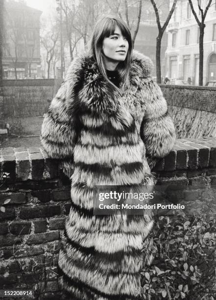 French singer and actress Francoise Hardy posing wearing a fur in piazza Sant'Ambrogio. Milan, 1960s