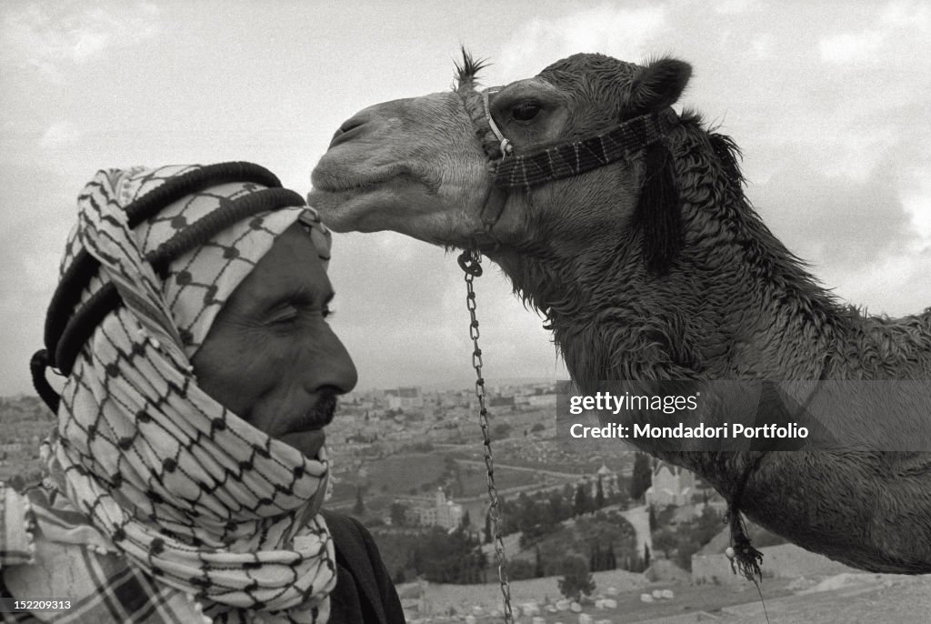 A man with his camel on the Mount of Olives above Jerusalem