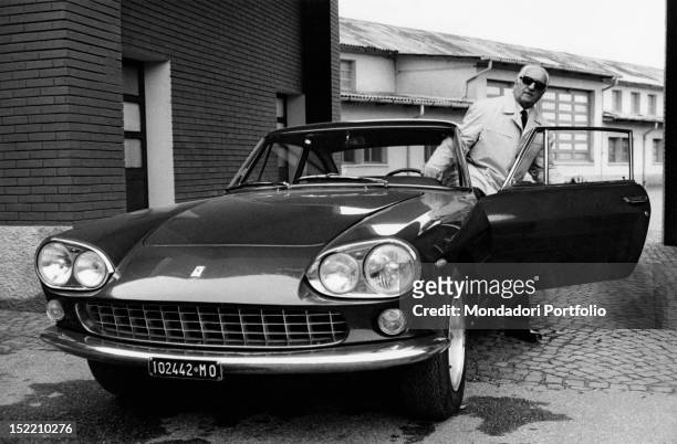 Italian entrepreneur and racing driver Enzo Ferrari getting off a car by his car manufacturer. 1966
