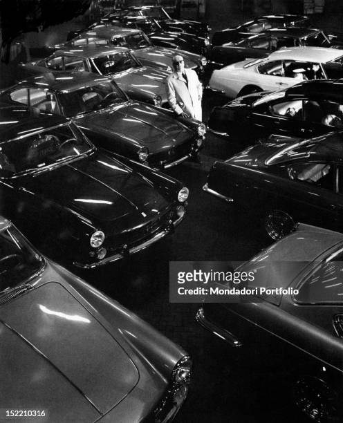 The Italian entrepreneur and driver Enzo Ferrari posing among his cars. Italy, 1960s