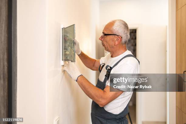 un electricista trabaja en la centralita de su casa - electrical panel box fotografías e imágenes de stock