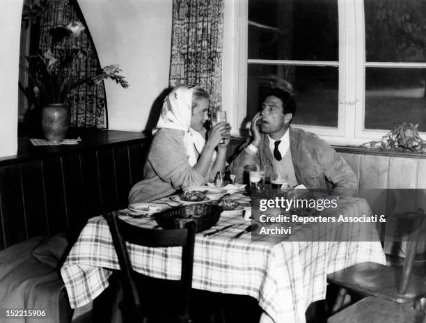 Maria Schell and Raf Vallone gaze into each other's eyes after dinner, while she sips some beer; this time the two actors are working on the film...