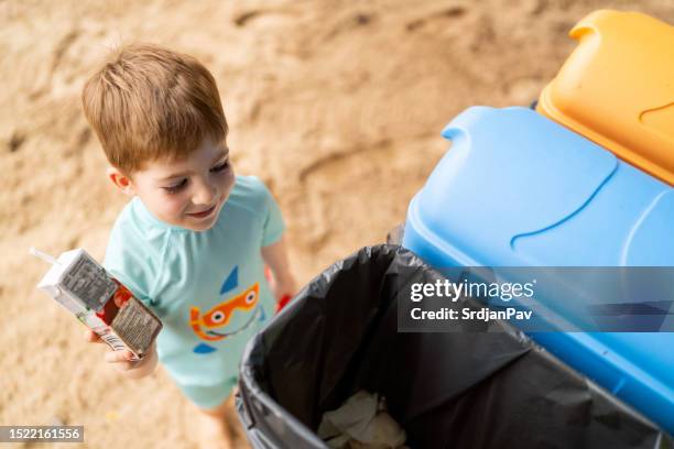 boy throwing used juice box into garbage bin - juice box stock pictures, royalty-free photos & images